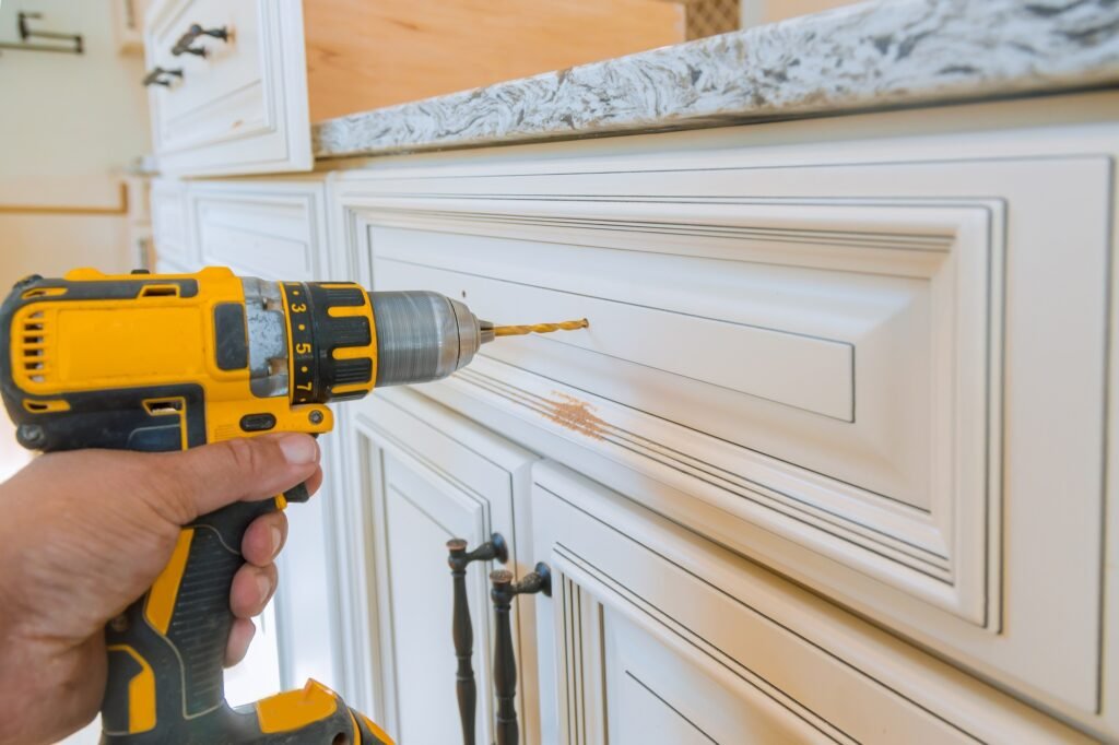 Home improvement contractor installing new custom kitchen cabinetsdrawers hinge