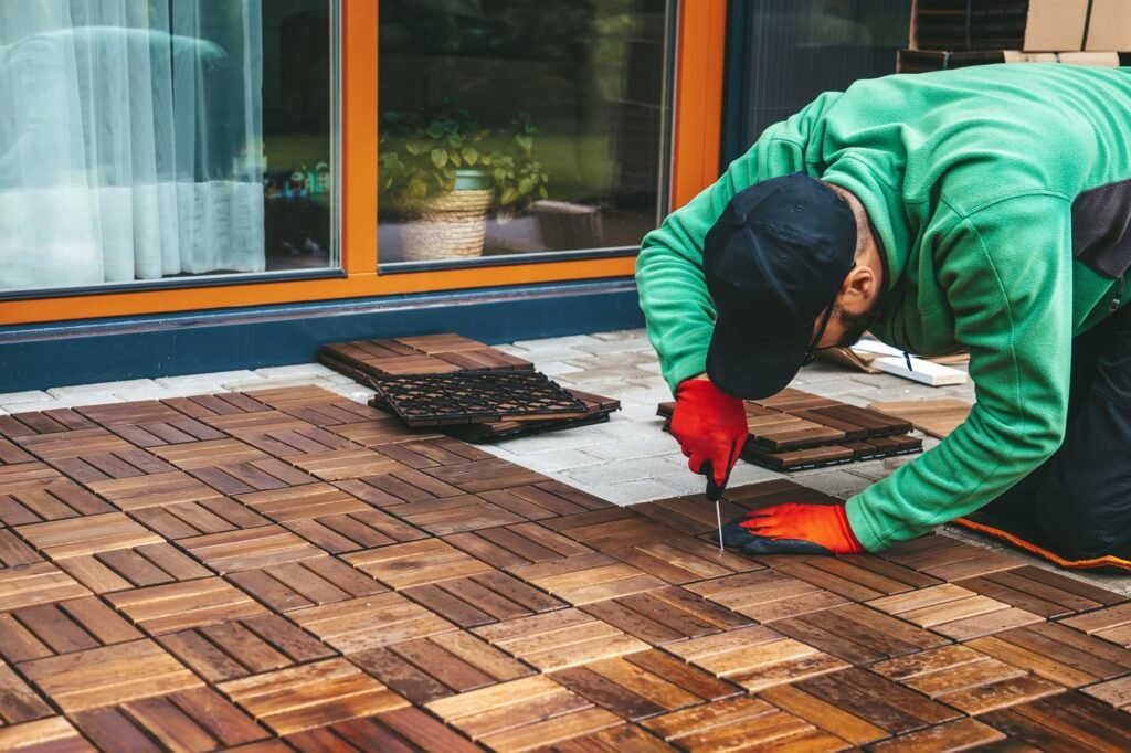 A man bringing the space to life with wooden flooring on the terrace